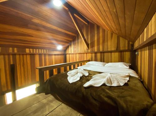 a bedroom with a bed in a wooden cabin at Village Arcoverde - Visconde de Mauá in Bocaina de Minas