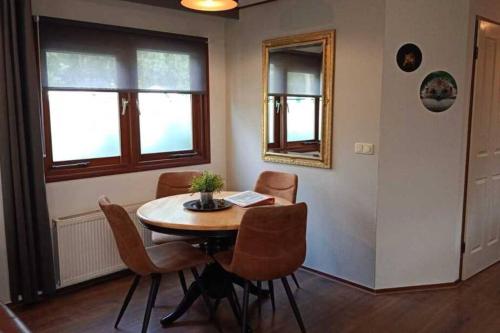Chalet op Vakantiepark Dennerhode في Doornspijk: غرفة طعام مع طاولة وكراسي