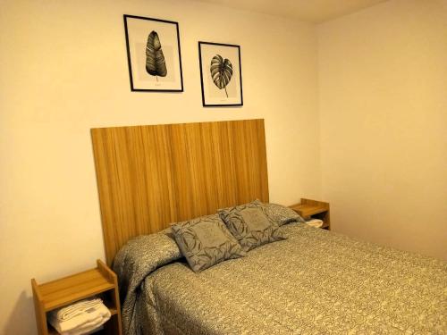 a bedroom with a bed and two pictures on the wall at Temporarios Santiago in Santiago del Estero