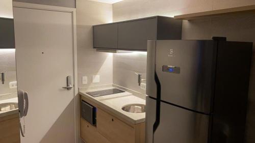 a kitchen with a refrigerator and a sink at Studio Moderno próximo ao Metrô in São Paulo