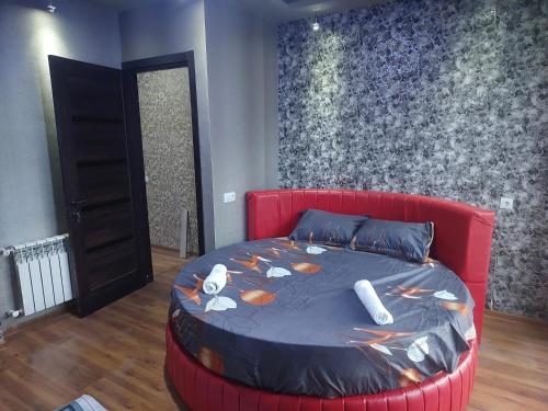 Un dormitorio con una cama roja con pescado. en Yosi villa, en Tiflis