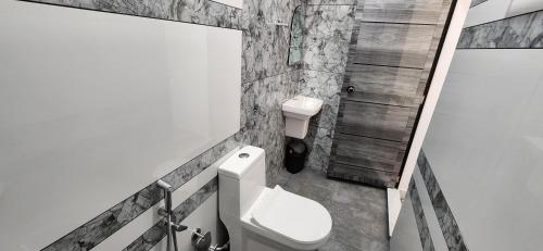 een badkamer met een wit toilet en een douche bij Bliss Beach Villa in Alleppey