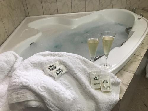 a bath tub with two glasses of champagne in it at Hotel Bergblick in Pomerode