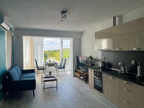 cocina y sala de estar con sofá y mesa en Тристаен апартамент Park View, en Targóvishte