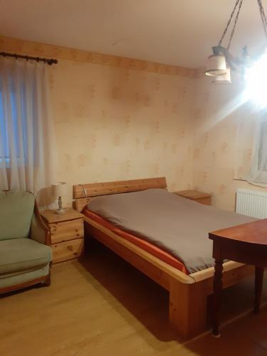 ein Schlafzimmer mit einem Bett, einem Stuhl und einem Tisch in der Unterkunft grande chambre lumineuse de 18 m² in Bust