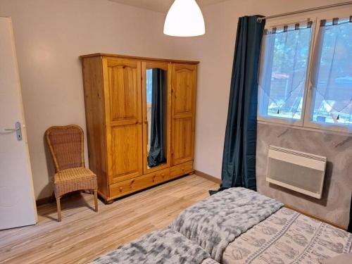 1 dormitorio con 1 cama, 1 silla y 1 ventana en Maison avec jardin au cœur du Bassin d'Arcachon en Gujan-Mestras