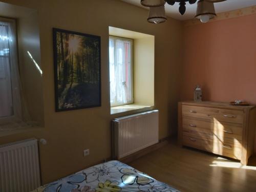 ein Schlafzimmer mit einem Bett, einer Kommode und einem Fenster in der Unterkunft grande chambre lumineuse de 18 m² in Bust