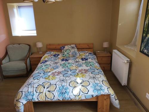 1 Schlafzimmer mit einem Bett mit Blumenbettdecke in der Unterkunft grande chambre lumineuse de 18 m² in Bust