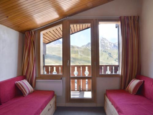 Cette chambre comprend 2 bancs roses et une grande fenêtre. dans l'établissement Appartement fonctionnel de 2 pièces avec balcon et casier à ski - FR-1-181-2155, à La Plagne Tarentaise
