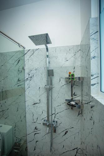a shower in a bathroom with a marble wall at SHERON RESORT in Unawatuna