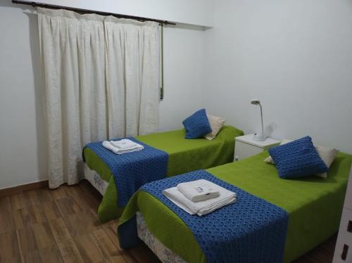 2 camas en una habitación de color verde y azul en Sol Pampa en Concordia