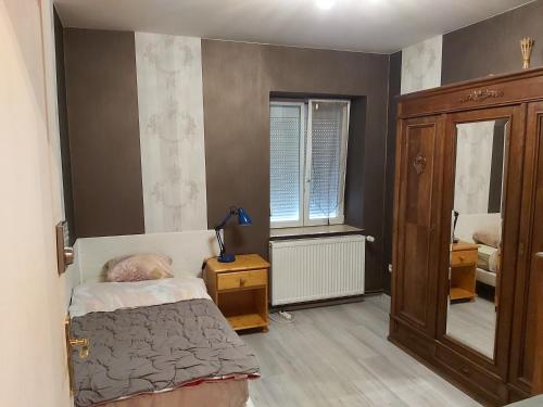 a small bedroom with a bed and a mirror at chambre en colocation in Bust