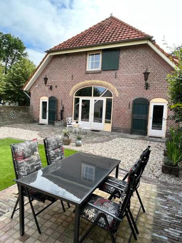 a table and chairs in front of a house at Gastenverblijf op unieke locatie De Kronkel op de Veluwe in Hoog-Soeren