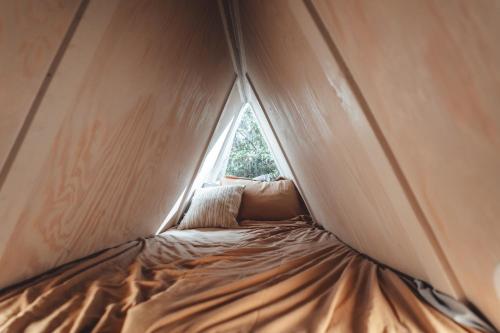 a bed in a tent with a window at Blue Brambler Glamping A-Frame in Rockbridge