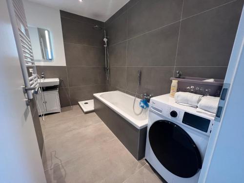 a bathroom with a washing machine and a sink at MOWO Apartmenthaus Altertheim in Unteraltertheim