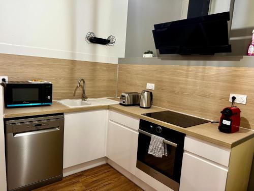 a kitchen with a sink and a stove top oven at République - Grande la Réal in Perpignan