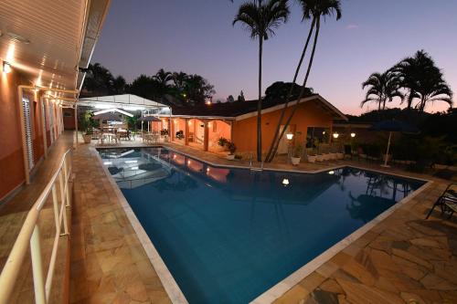 a swimming pool in a house at night at Pousada Casa Doce Vida in Águas de Lindóia