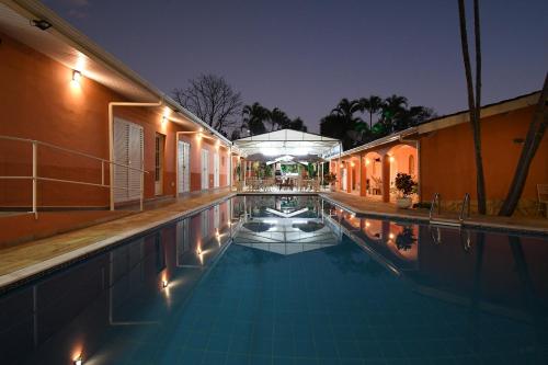 a swimming pool at night with the lights on at Pousada Casa Doce Vida in Águas de Lindóia