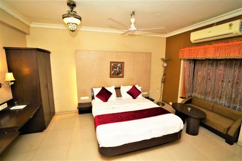a hotel room with a bed and a couch at New Hotel Europa Inn in Rajkot