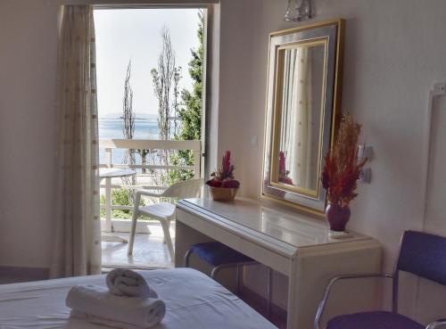 1 dormitorio con escritorio, espejo y ventana en Hotel Theoxenia en Mesolóngion