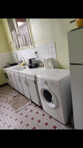 a kitchen with a washing machine and a sink at Maison Lison gare in Moon-sur-Elle