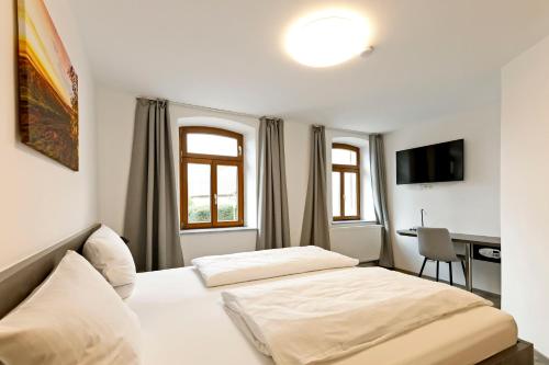 1 dormitorio con 2 camas y escritorio. en Vinotel Weinstrasse en Herxheim am Berg