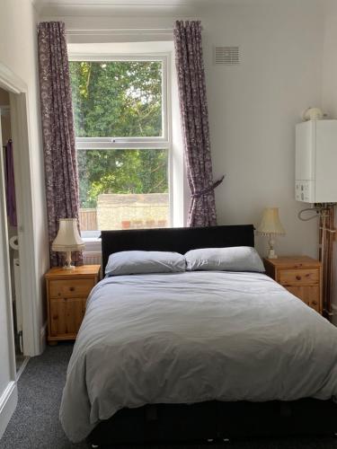 a bedroom with a large bed and a window at The Snug on Hornby in Morecambe