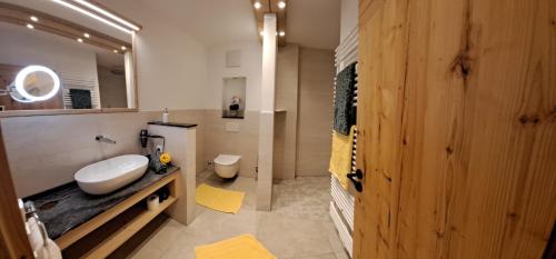 een badkamer met een wastafel, een toilet en een spiegel bij Landhaus Langackerbauer in Bad Reichenhall