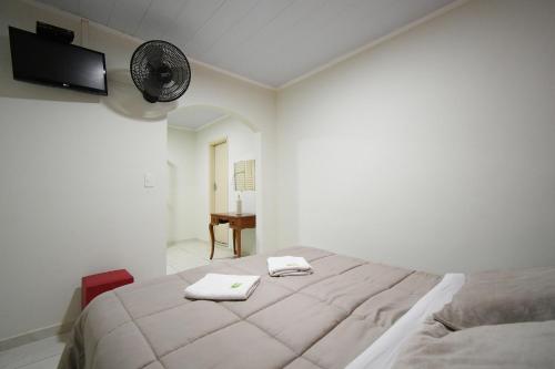 a bedroom with a bed with two towels on it at Pousada Casa Doce Vida in Águas de Lindóia