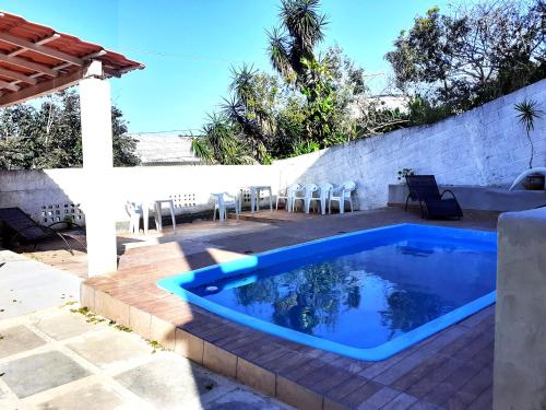 a swimming pool on a patio with chairs around it at Casa na praia de Setiba com panorama fantástico in Guarapari