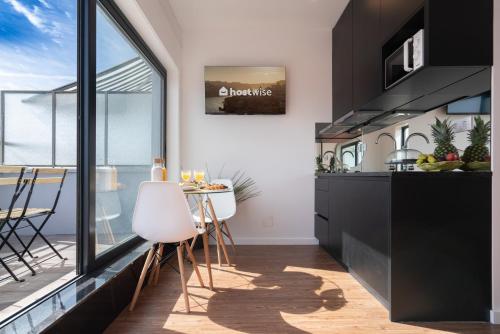 une cuisine avec une table et une grande fenêtre dans l'établissement Sunny Bright Flat w Balcony - Ace Location, à Porto