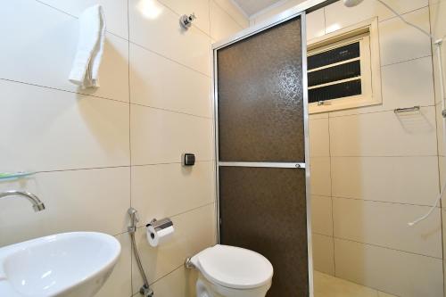 a bathroom with a shower and a toilet and a sink at Pousada Casa Doce Vida in Águas de Lindóia