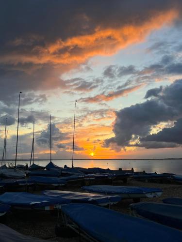 eine Gruppe von Booten, die bei Sonnenuntergang am Strand geparkt sind in der Unterkunft The Snug- With Private parking in Whitstable