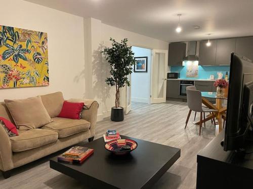 ein Wohnzimmer mit einem Sofa und einem Tisch in der Unterkunft Stunning and Spacious 2bed flat in central Woking in Woking