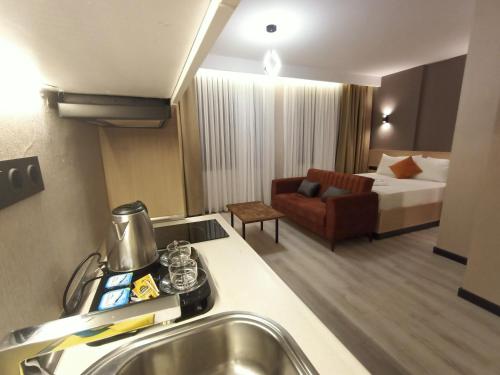 um quarto de hotel com uma cama e uma cozinha com um lavatório em NEW FALCON Palas OTEL em Istambul