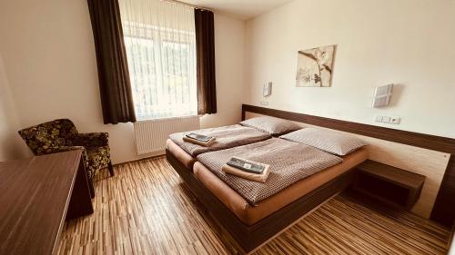 a bedroom with a bed and a table and a window at Penzion Ranch in Hořovice