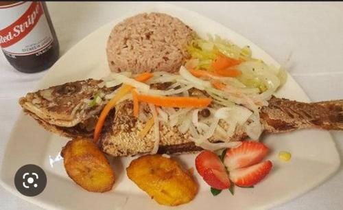 a white plate of food with a sandwich and fruit at Beautiful 1-Bed House in New Harbour Village 3 Old Harbour St Catherine Jamaica Secured gated community in Old Harbour