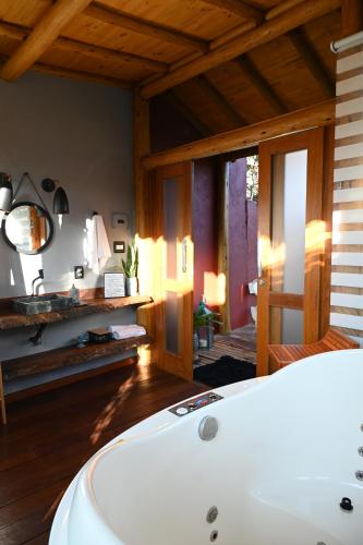 a bathroom with a white bath tub in a room at Casa das flores - Lavras Novas in Lavras Novas