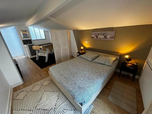 Dormitorio pequeño con cama y mesa en Le Saint Maixent, Maison de Ville, Baby Foot, wifi, en Saint-Maixent-lʼÉcole