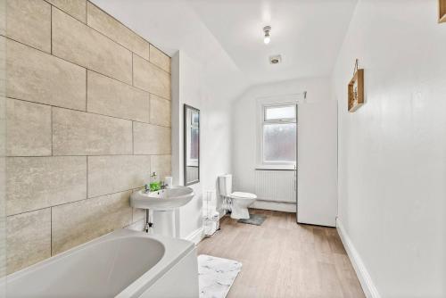 a bathroom with a tub and a sink and a toilet at Sophisticated 2 bed in Doncaster sleeps 6! in Balby