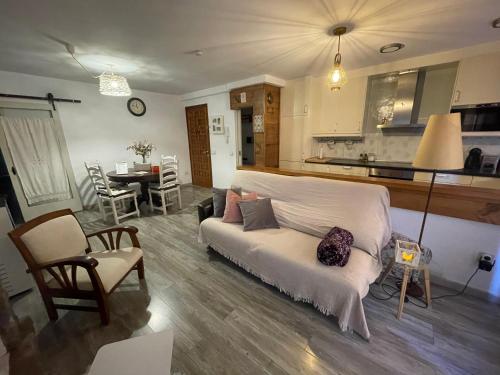 un soggiorno con divano bianco e una cucina di Apartament Pic de la dona a Camprodon