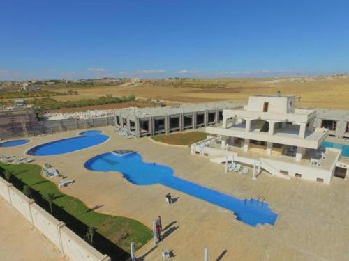 a large building with a pool in front of it at Akitu Hotel in Midyat