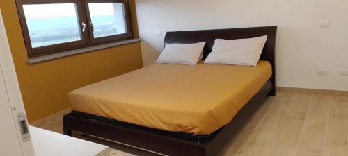 ein kleines Schlafzimmer mit einem Bett mit zwei Kissen in der Unterkunft Appartamento dei Tigli in Bra