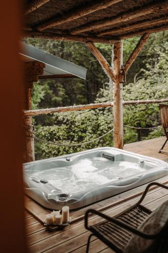 a bath tub sitting on a deck with a chair at Wooden Nest in Durbuy