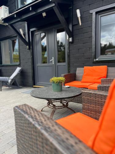 a patio with orange cushions and a table and chairs at Complex A Toplita in Topliţa