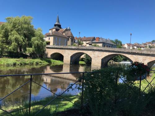 a bridge over a river in a town at La Grange Mignonne in Teneze