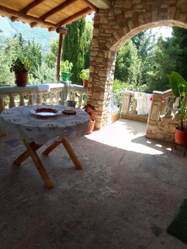 una mesa en un patio al aire libre con un arco en Shtepia e Llambros en Vlorë