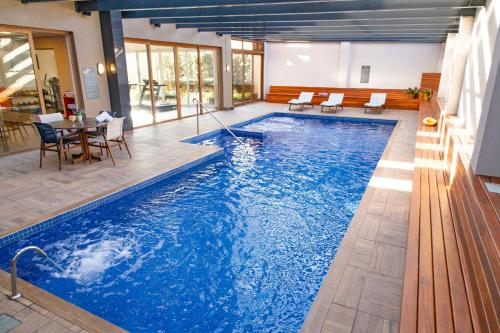 uma piscina numa casa com mesa e cadeiras em Prodigy Gramado em Gramado