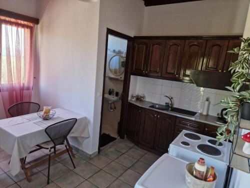 uma cozinha com uma mesa e uma cozinha com um fogão e um lavatório em Jason&Maria em Ágios Matthaíos