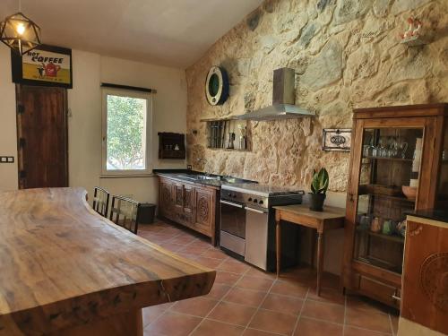 Loft Carriones في Castilléjar: مطبخ مع طاولة خشبية وموقد فرن علوي